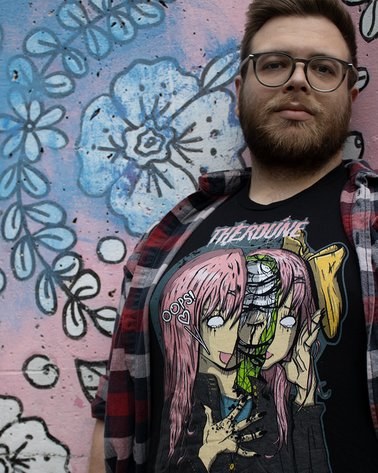 Person leaning on graffiti wall wearing black shirt with anime stylized woman, head splitting open revealing a crying woman inside. Speech text saying "Oops!" with Therdune logo on top in pink.