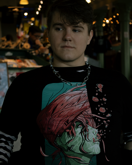 Person in a busy cafe wearing a black shirt with a green-skinned woman with pink hair flowing underwater. Pink air bubbles. The phrase "therdune - did you take everything you need?" written on bottom