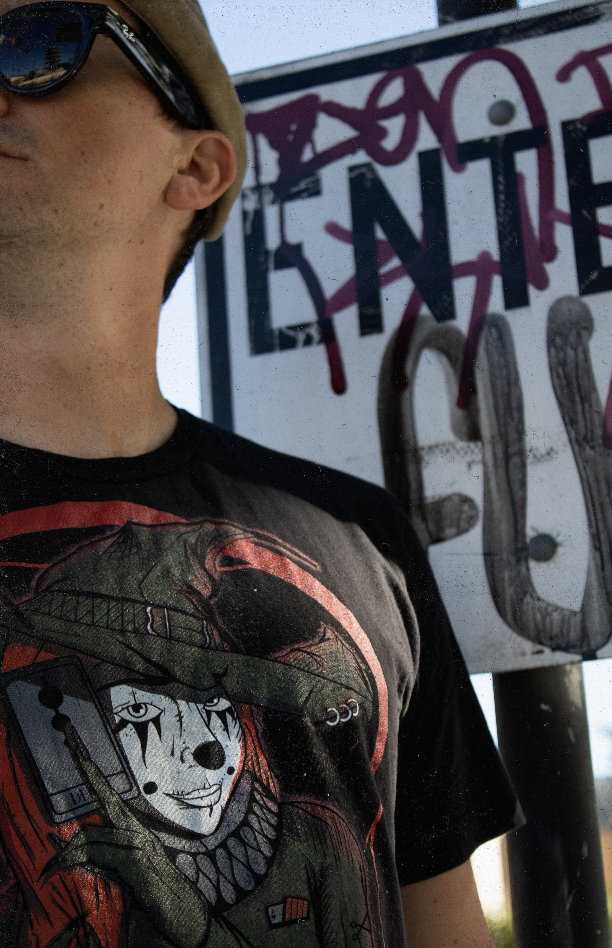 Person wearing black shirt with a graphic of a witch in clown makeup, holding a tarot card in front of a red crescent moon. "Therdune" logo on bottom of graphic.
