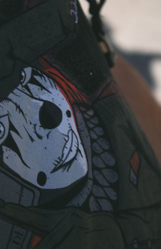 Close shot of a graphic of a witch in clown makeup, holding a tarot card in front of a red crescent moon.